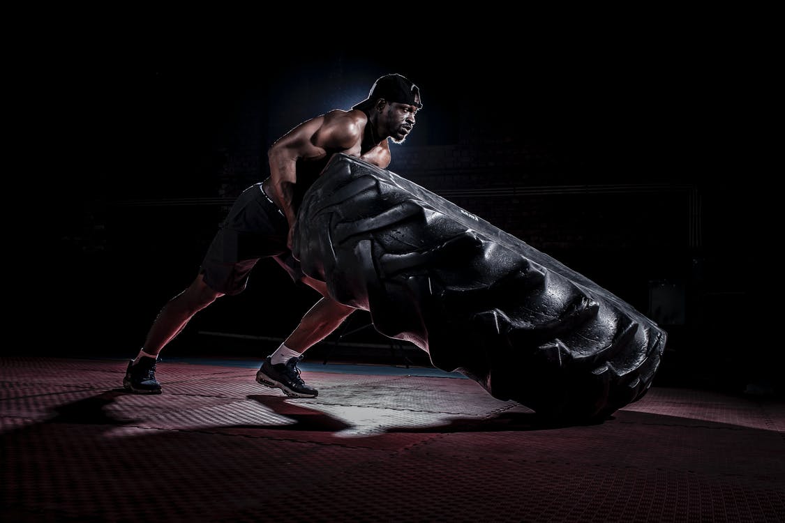 man doing exercise with tyre